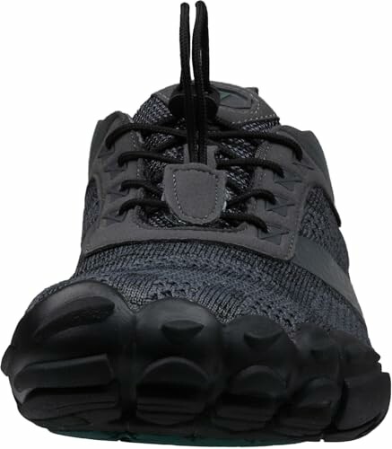 Front view of a black athletic shoe with laces, highlighting the shoe's sleek design