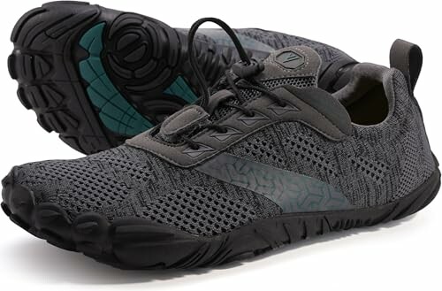 Gray athletic shoes with black soles, highlighting the shoe's minimalist design