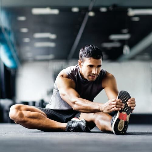 Man stretching on gym floor