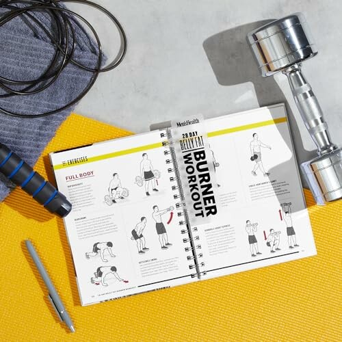 Exercise book with workout gear and dumbbell on a mat